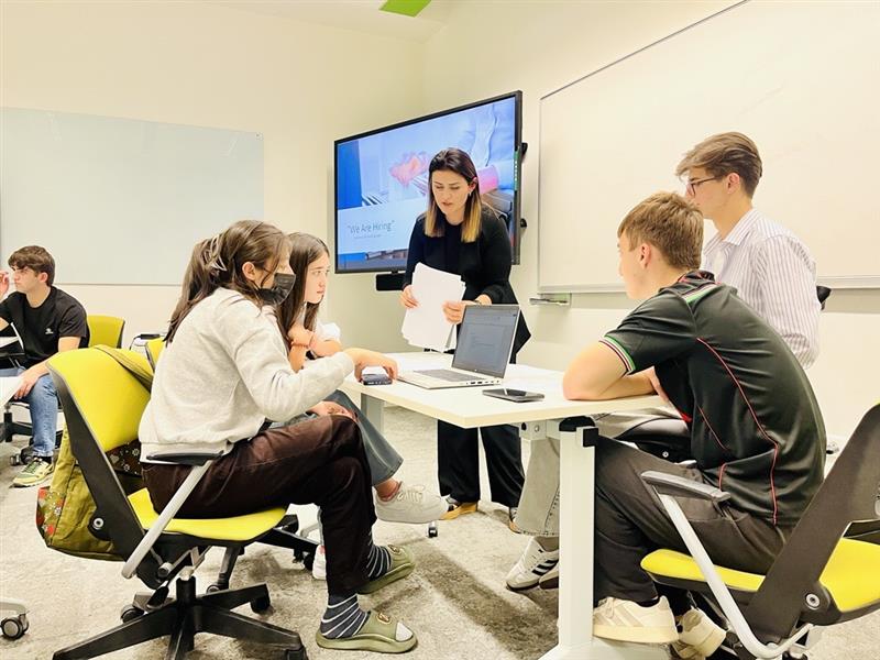 Zarangez Pironova, Communications and Media Specialist at AKF Tajikistan, guiding students through a group work activity